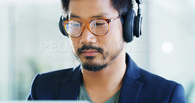 Buy stock photo Developer, headphones or man with glasses in office for technology, podcast playlist or coding. Face, music and Asian programmer on computer with eyewear for design review, development or reflection
