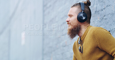 Buy stock photo Relax, streaming or man with headphones, outdoor and listening to playlist on tech, song and calm. Wall space, radio or person with headset for music, street or audio for break on weekend or chilling