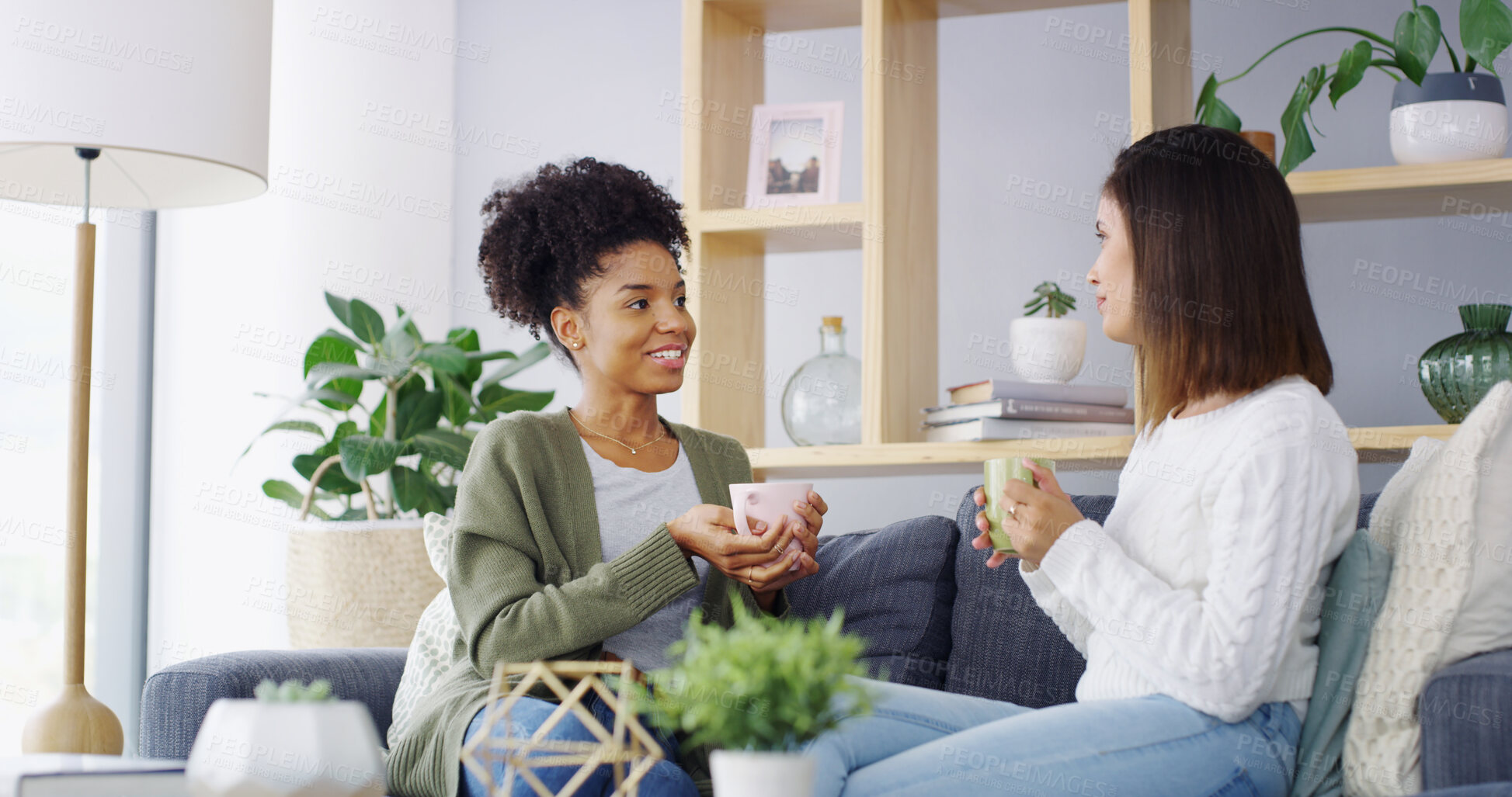 Buy stock photo Home, coffee and women on sofa, talking and bonding together in living room. People, relax and happy friends with cappuccino, gossip and support with comfort, share secret and weekend break in lounge
