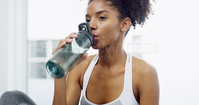Buy stock photo Active, woman and drink water at house for hydration, exercise break and diet nutrition of wellness. African, person and refreshing with training recovery, electrolytes beverage and fitness self care