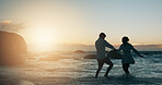 Playful, couple and love by sunset on beach, vacation holiday and bonding together for anniversary. Ocean, man and woman with holding hands for embrace, travel adventure or connection in relationship