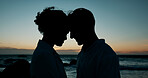 Forehead touch, beach and couple at sunset for bonding, relationship and relax on weekend. Dating, travel and silhouette of man and woman by ocean for romance on holiday, vacation and love in nature