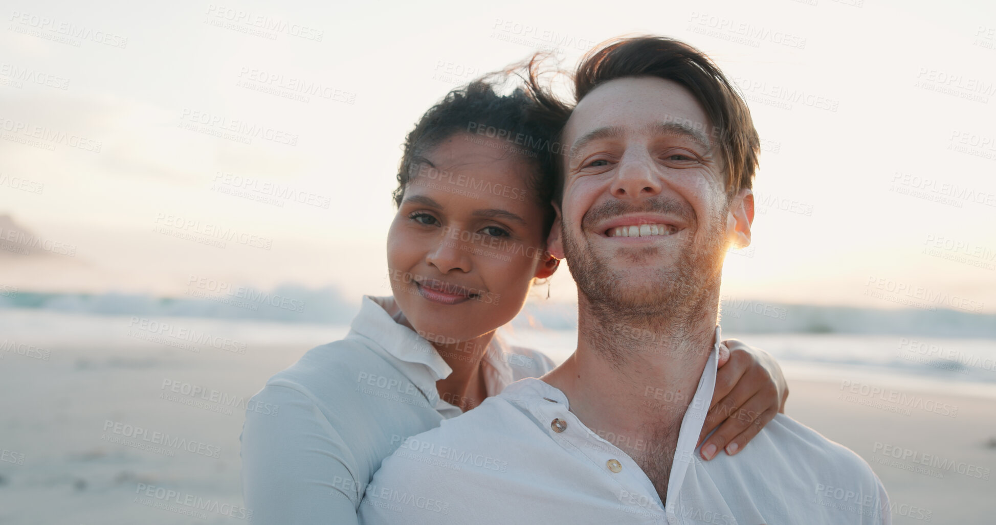 Buy stock photo Happy couple, sunset and portrait at beach on holiday, summer vacation and travel together. Ocean, man and woman embrace outdoor for romantic date, love or care in interracial relationship with space