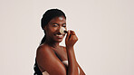 Brush, cosmetics and black woman in studio with face, beauty or makeup for getting ready. Happy, cosmetology and African female person with blush for facial color or glow by white background.
