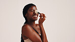 Brush, beauty and black woman in studio with face, makeup or cosmetics for getting ready. Happy, cosmetology and African female person with blush for facial color or glow by white background.