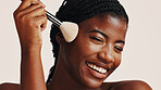 Brush, makeup and black woman in studio with beauty, face or cosmetics for getting ready. Happy, cosmetology and African female person with blush for facial color or glow by white background.