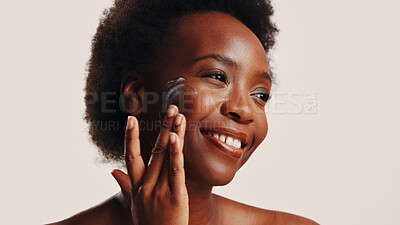 Buy stock photo Smile, black woman and lotion on face in studio for facial hydration, treatment and sunscreen protection. Female person, apply cream and spf cosmetics for dermatology, anti aging and white background