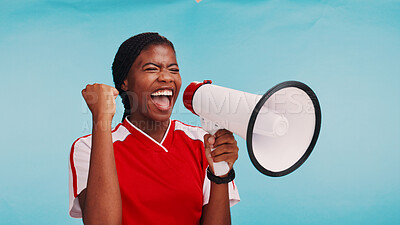 Buy stock photo Woman, loudspeaker and celebration in studio with sports for fist pump, goal or soccer by blue background. African athlete, girl and bullhorn for cheers, motivation or support for football tournament