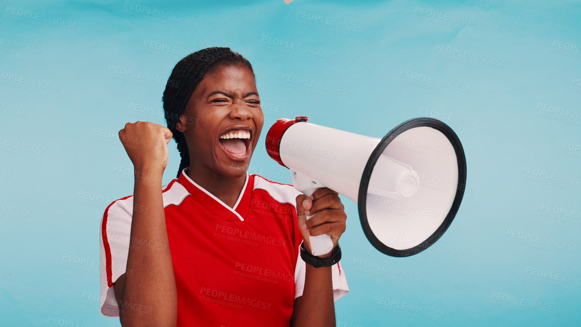 Buy stock photo Woman, loudspeaker and celebration in studio with sports for fist pump, goal or soccer by blue background. African athlete, girl and bullhorn for cheers, motivation or support for football tournament