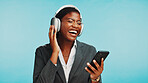 Headphones, music and business woman in studio to relax with audio, track and playlist. Professional, corporate and African person with phone listening to radio, song and streaming on blue background