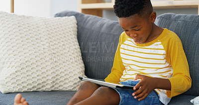 Buy stock photo Tablet, home and African kid on sofa for reading ebook, learning app or streaming cartoon video. Relax, boy and child in living room on technology for entertainment, watch movies or play games online