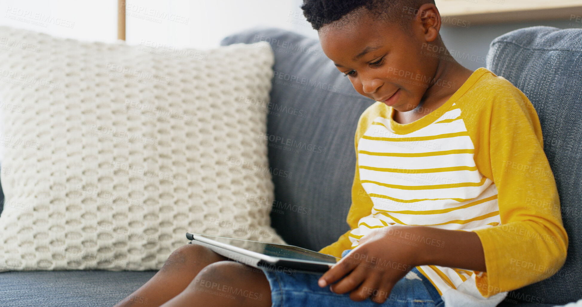 Buy stock photo Tablet, home and African kid online on sofa for reading ebook, learning app or streaming cartoon video. Relax, boy and child in living room on technology for entertainment, watch movies or play games
