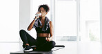 Girl, gym and drinking water on floor, fitness and break with hydration, wellness and detox at training. Woman, bottle and liquid for health, electrolytes and benefits with rest at exercise club