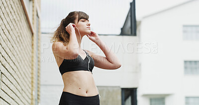 Buy stock photo Earphones, fitness and woman in city for running, exercise or health activity with listening to music. Sports, audio tech and female athlete streaming workout playlist for cardio in urban town.