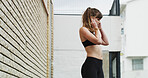 Earphones, sports and woman in city for running, exercise or health activity with listening to music. Fitness, audio tech and female athlete streaming workout playlist for cardio in urban town.