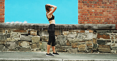 Buy stock photo Girl, runner and tired with earphones in city by wall, space and streaming with sound, subscription and exercise. Woman, audio and profile with music for fitness, training or fatigue on road in Italy