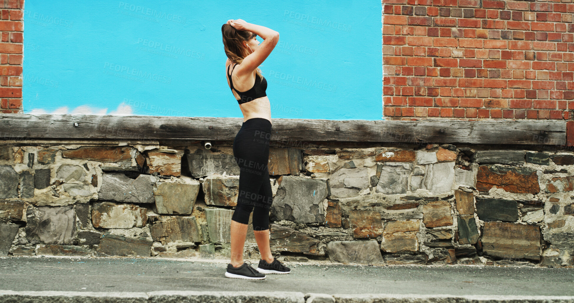 Buy stock photo Girl, runner and tired with earphones in city by wall, space and streaming with sound, subscription and exercise. Woman, audio and profile with music for fitness, training or fatigue on road in Italy