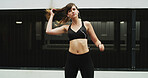 Girl, runner and earphones in city, training and perspective with start, exercise and audio tech. Woman, wellness and hair with streaming subscription, sound and listen to music for fitness in Spain
