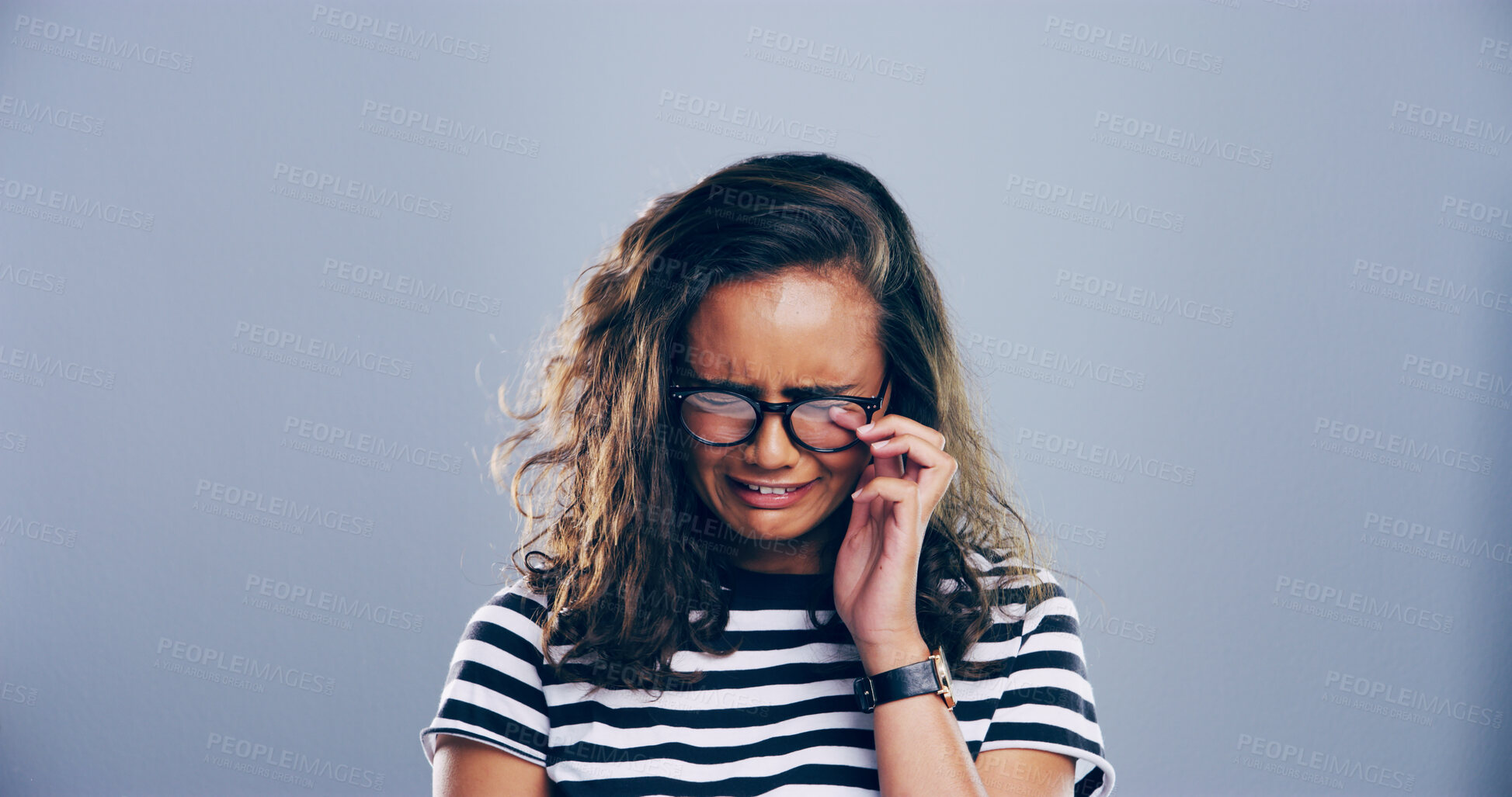 Buy stock photo Sad, girl and crying with emotions in studio for mourning loss, broken heart and bad news. Person, mockup space and grief with depression, mental health and ptsd for trauma memory on gray background