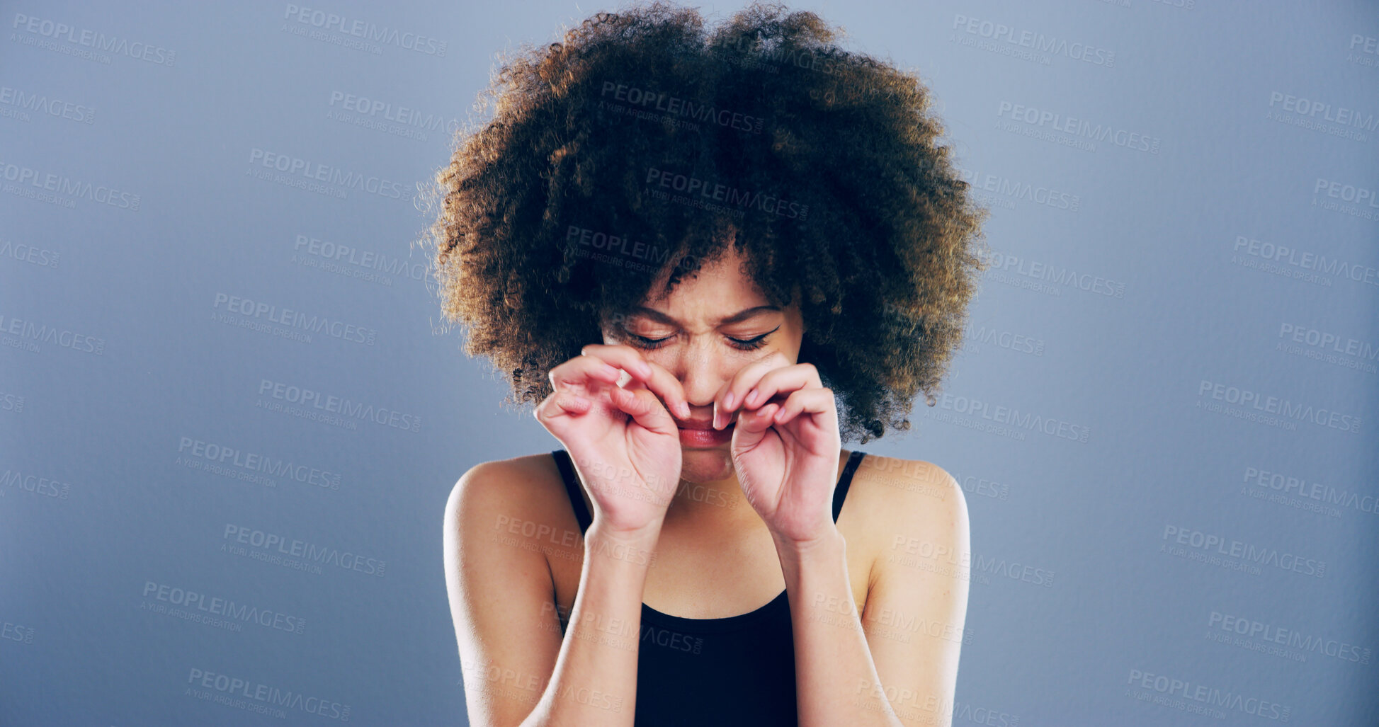 Buy stock photo Crying, sad and woman in studio, tears and emotional reaction on blue background. Person, model and girl with depression, stress and grief with loss, mourning and broken heart with sorrow and upset