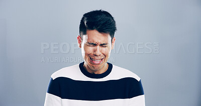 Buy stock photo Sad, man and crying for sorrow in studio for mourning loss, broken heart and bad news. Mockup space, grief and male person with depression, mental health and ptsd of trauma memory on gray background