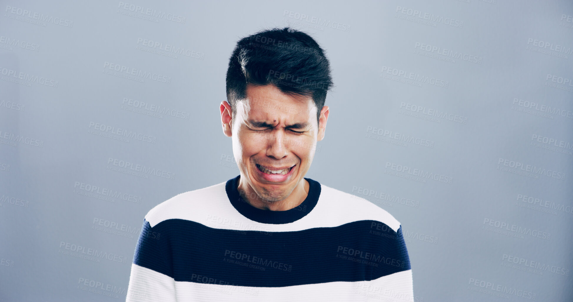 Buy stock photo Sad, man and crying for sorrow in studio for mourning loss, broken heart and bad news. Mockup space, grief and male person with depression, mental health and ptsd of trauma memory on gray background