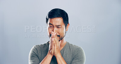 Buy stock photo Sad, Asian man and cry with tears in studio for mourning loss, broken heart and bad news. Grief, mockup space and person with depression, mental health and ptsd with trauma memory on gray background