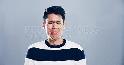 Buy stock photo Man, grief and crying for sorrow in studio for mourning loss, broken heart and bad news. Sad, mockup space and male person with depression, mental health and ptsd for trauma memory on gray background