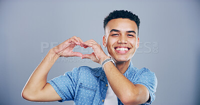 Buy stock photo Happy man, portrait and heart hands with love sign, gesture or romance on grey background space in studio. Student person, smile and emoji or shape, symbol and kindness for valentines day date mockup