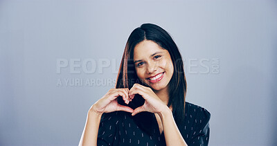 Buy stock photo Woman, smile and heart hands with love sign, gesture or romance on grey background space in studio. Happy person, portrait and emoji or shape, symbol and kindness for valentines day date mockup