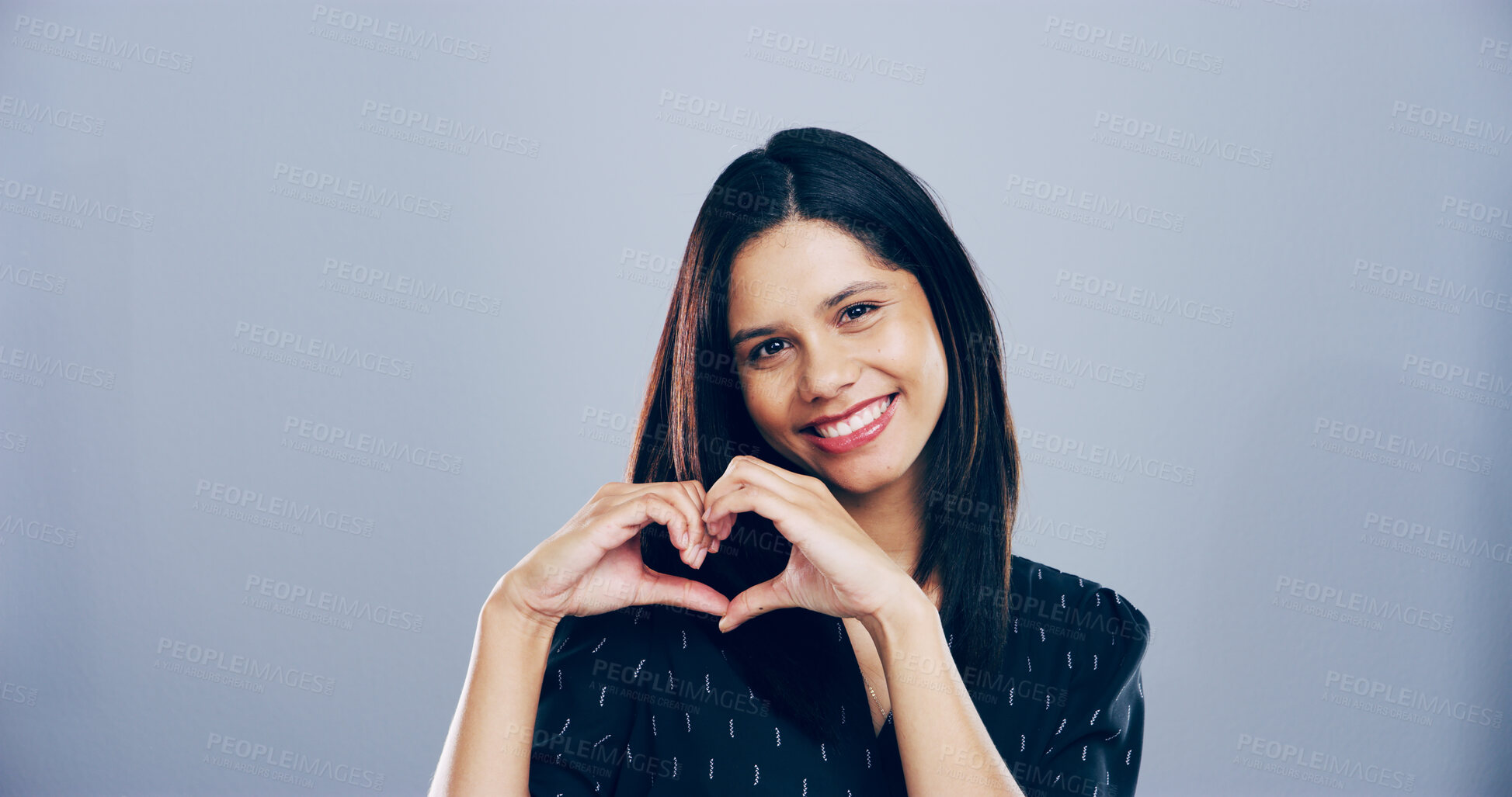 Buy stock photo Woman, smile and heart hands with love sign, gesture or romance on grey background space in studio. Happy person, portrait and emoji or shape, symbol and kindness for valentines day date mockup