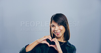 Buy stock photo Portrait, heart hands or happy woman with smile with mockup space isolated on gray background in studio. Peace, support sign and gesture with love emoji, icon or symbol for hope or charity donation