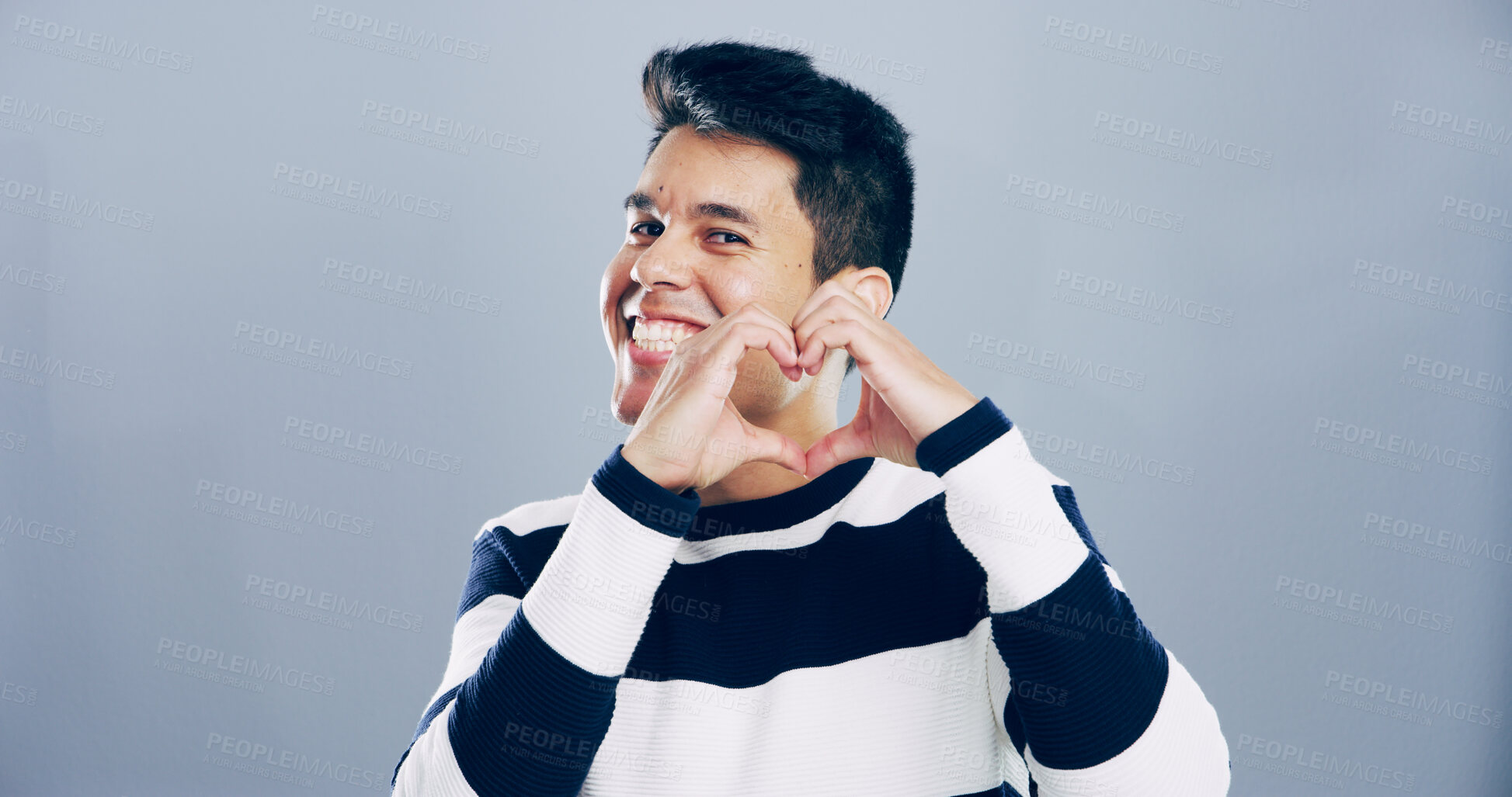 Buy stock photo Love sign, heart hands and portrait of man for support with charity or health isolated on gray background. Mockup space, smile and emoji for care, romance or wellness with symbol or shape in studio