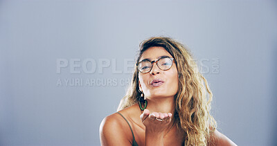 Buy stock photo Happy woman, portrait or blowing with kiss for love, affection or romance on a gray studio background. Creative, female person or model with gesture, glasses or palm for care or flirt on mockup space