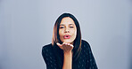 Portrait, woman and blowing kiss in studio, flirting and gesture for romance for valentines day or space. Blue background, mockup and person with expression for love, happy and girl with pout in USA