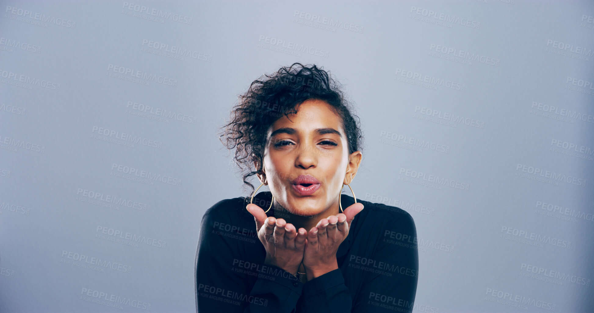 Buy stock photo Love, woman and blowing kiss in studio, portrait and gesture for romance for valentines day or space. Blue background, mockup and black person with expression for flirting, happy and girl with pout