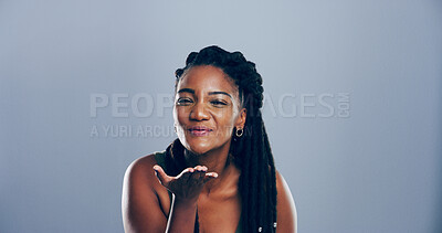 Buy stock photo Portrait, black woman and blowing kiss with love for romance, affection or greeting on a gray studio background. Student, female person or model with care, palm or flirt in distance on mockup space