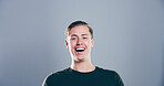 Portrait, man and happy in studio for funny joke, crazy comedy and smile isolated on gray background with space. Face, lol and male person with humor, excited and laughing with comic emotion in USA