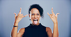 Crazy, tongue out and woman with rock hand gesture, studio or portrait for heavy metal on gray background. Culture, edgy female rocker or e person with devil horn sign, funky emoji or punk symbol