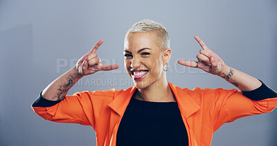 Buy stock photo Portrait, edgy or happy woman with rock hand gesture in studio for expression or space on gray background. Culture, cool female rocker and crazy model with devil horn sign, funky emoji or punk symbol