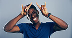 Space, happy or portrait of black man with rock hand gesture in studio for wild expression on gray background. Crazy, edgy rocker and African person with devil horn sign, funky emoji and punk symbol