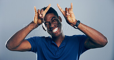 Buy stock photo Space, happy or portrait of black man with rock hand gesture in studio for wild expression on gray background. Crazy, edgy rocker and African person with devil horn sign, funky emoji and punk symbol