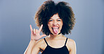Portrait, afro and girl with rock hand gesture or tongue out isolated in studio space on gray background. Culture, edgy female rocker and crazy woman with devil horn sign, funky emoji and punk symbol