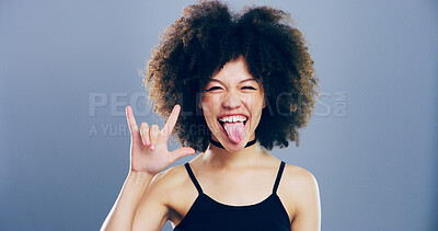 Buy stock photo Portrait, afro and girl with rock hand gesture or tongue out isolated in studio space on gray background. Culture, edgy female rocker and crazy woman with devil horn sign, funky emoji and punk symbol