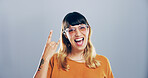 Rock and roll, sunglasses and portrait of woman in studio with hand gesture for rebel, heavy metal or edgy attitude. Space, fashion and person with punk sign, emoji and devil horns on gray background