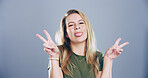 Portrait, peace sign and woman in studio, funny and confidence on blue background. Face, person and model with hand gesture, support or tongue out with symbol, good vibes or silly with emoji or goofy