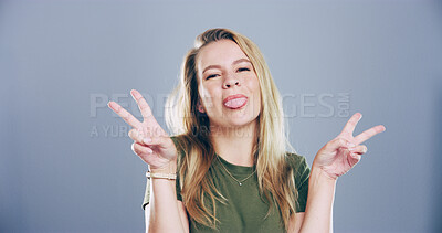 Buy stock photo Portrait, peace sign and woman in studio, funny and confidence on blue background. Face, person and model with hand gesture, support or tongue out with symbol, good vibes or silly with emoji or goofy