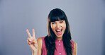 Portrait, peace sign and woman in studio, excited and confidence on blue background. Face, person and model with hand gesture, support and icon with symbol, good vibes and emoji with happiness