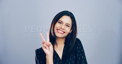 Buy stock photo Portrait, peace sign and woman in studio, support and confidence on blue background. Face, happy person and model with hand gesture, icon and agreement with symbol, good vibes and emoji with kindness