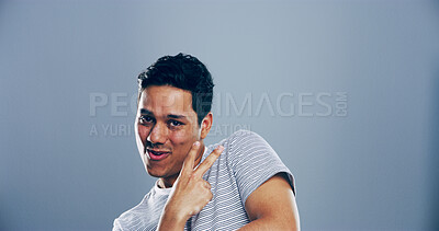 Buy stock photo Portrait, space and man with peace sign in studio with positive attitude, confidence or facial expression. Grey background, casual mockup and male model for cool gesture, satisfaction or v symbol